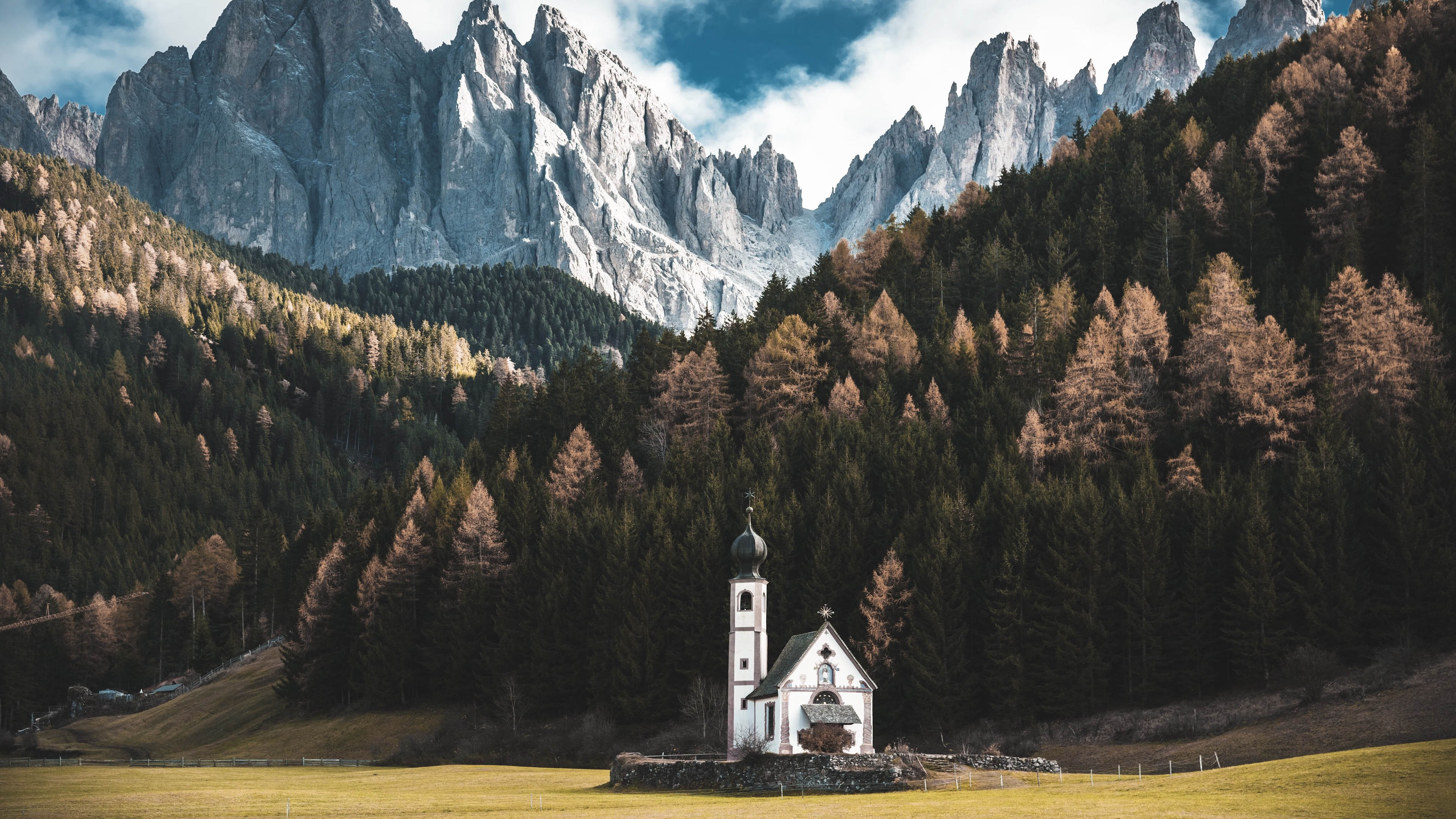 A small church in front of impressive mountains